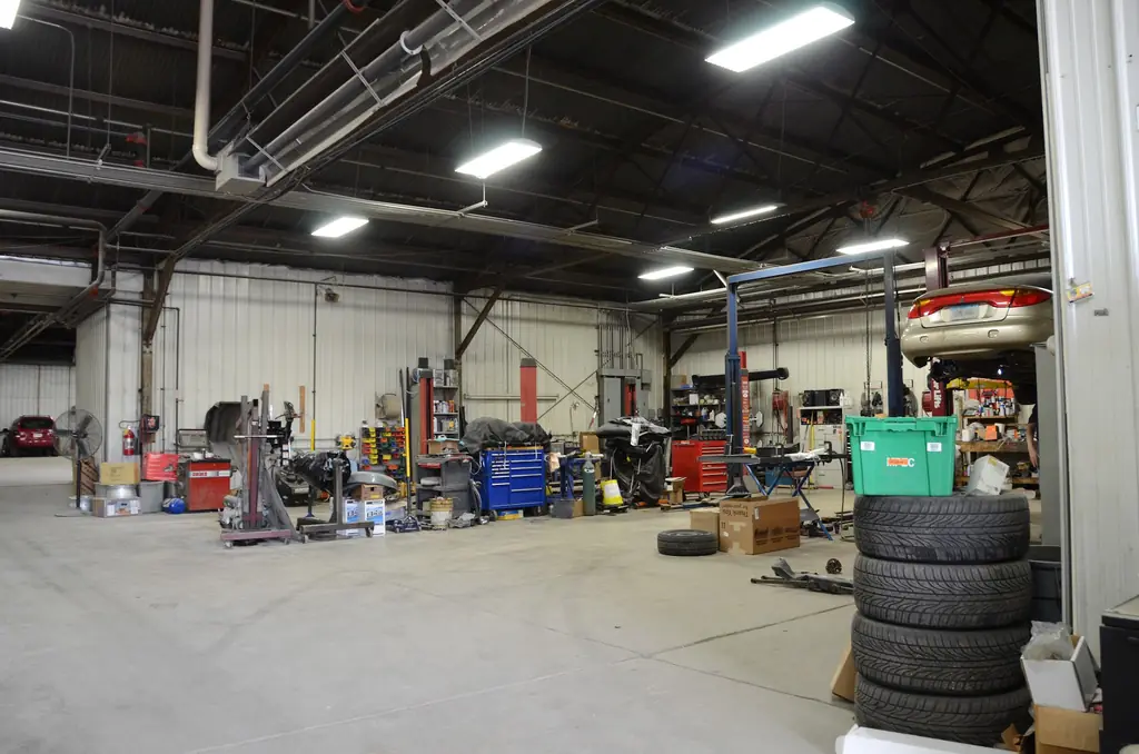 A vehicle raised in the shop bay with technician tool chests along the wall