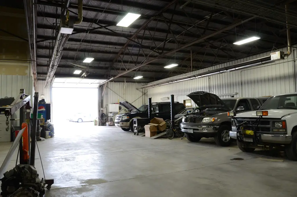 The main bay at Andrews Collision Center with several vehicles in for repair